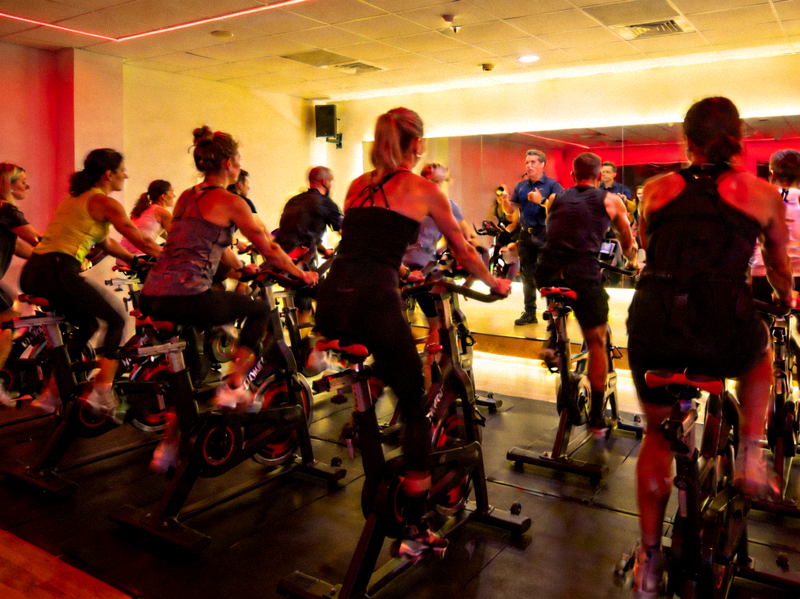 动感单车课程，学员在音乐节奏中进行室内骑行训练